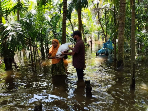 বন্যা কবলিত মানুষের মাঝে ত্রাণ সামগ্রী বিতরণ।